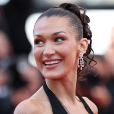 Bella Hadid glances away from the camera wearing diamond earrings