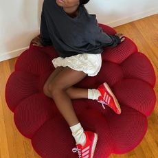 Aude-Julie Alingue in a black top, bubble skirt, and pink and red Adidas sneakers.