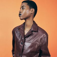 A zara model wearing a burgundy leather jacket and black lipstick.