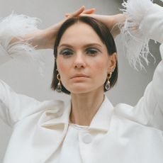 Woman looking into camera, wearing Pamela Love jewelry, for photoshoot campaign.