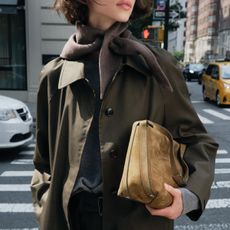 Woman in green trench coat and suede bag