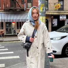 vivian wears trench coat and blue balaclava while crossing NYC streets. 